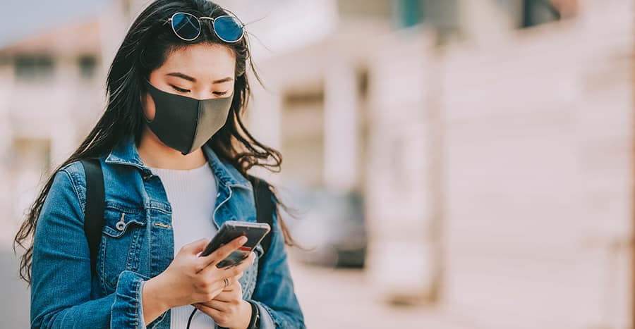 Woman wearing face mask while texting